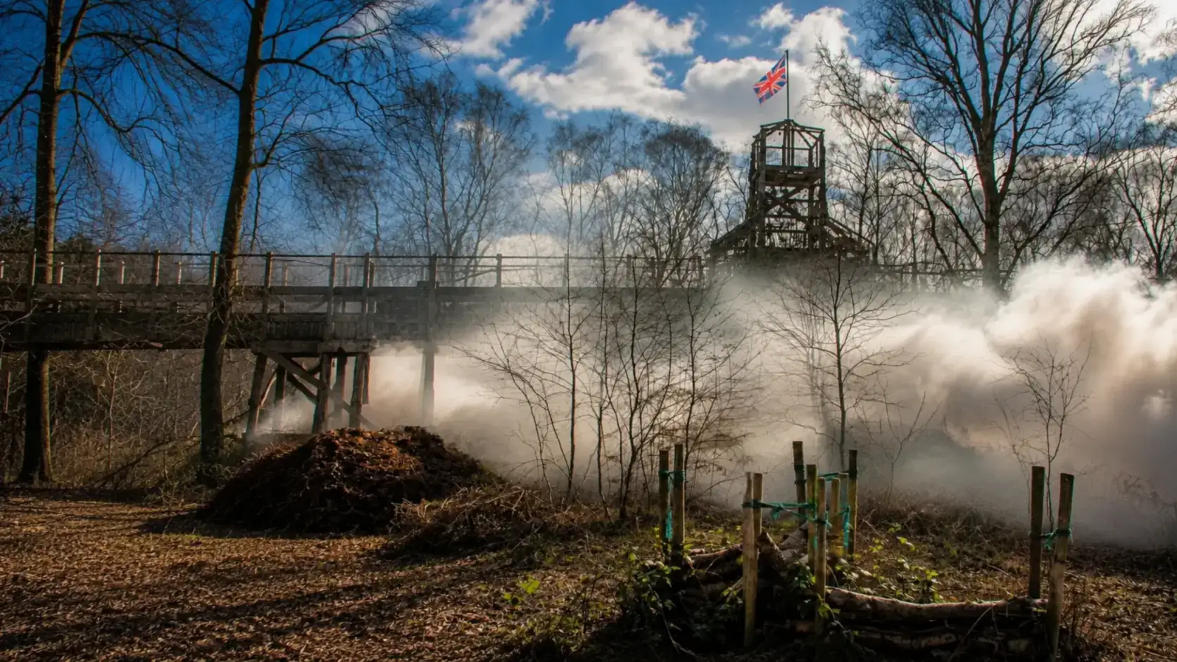 Smoke rolling across a game zone beside the watchtower at Yorkshire Outdoor Activity Park