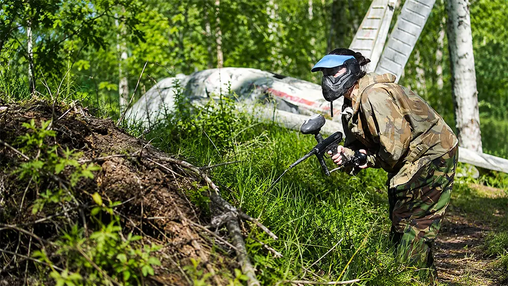 Players moving through the woods during a paintball game